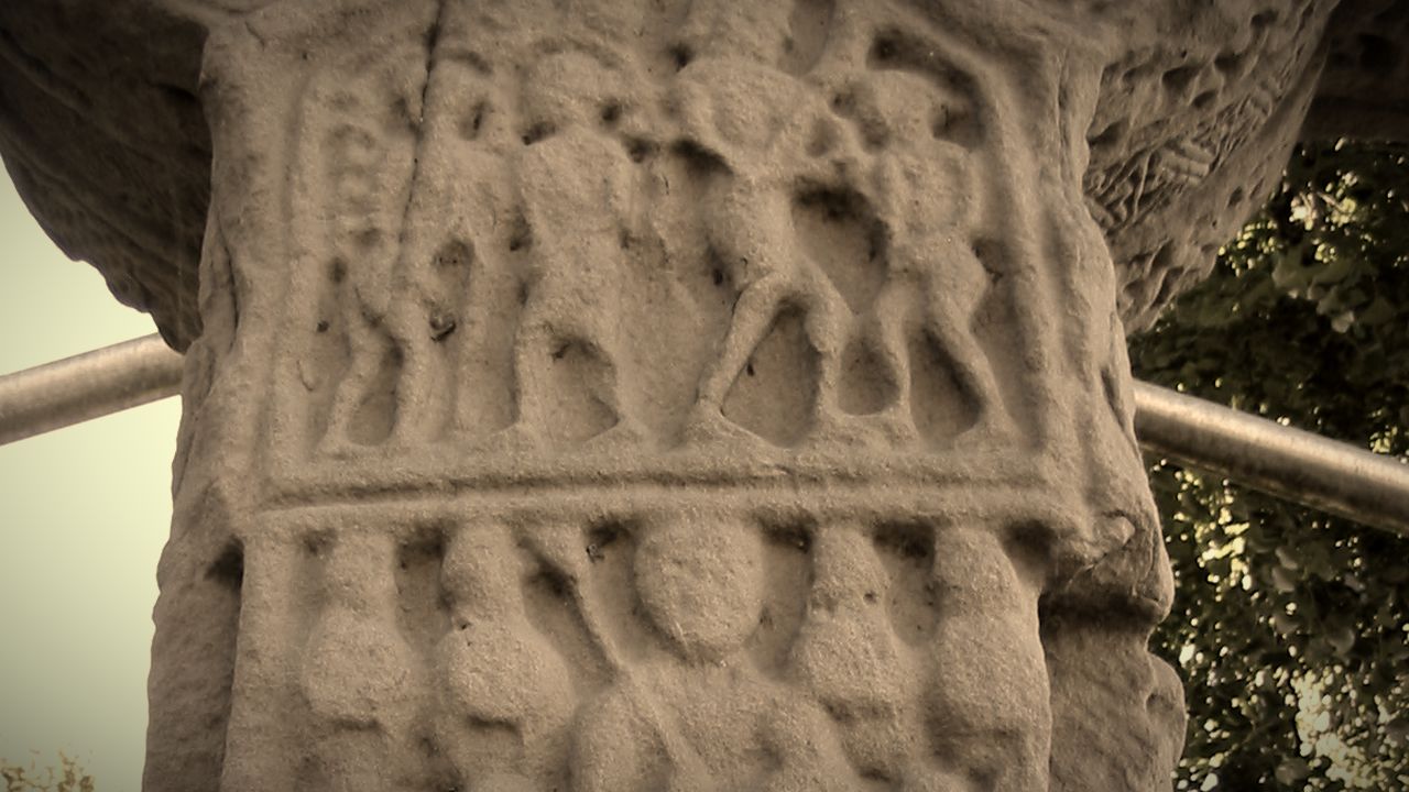 Carved figure panels on the east face of the Market Cross in Kells, Co. Meath, in close-up; warm sepia tones