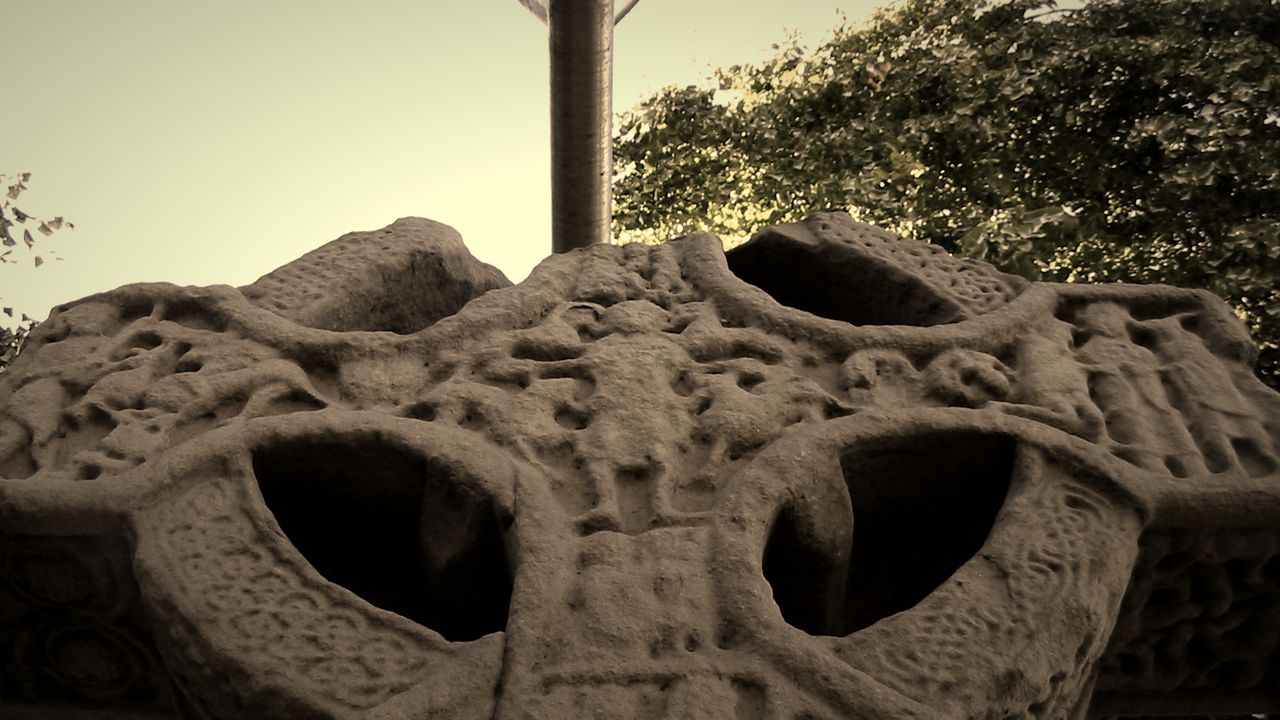 Carved head of the Market Cross in Kells, close up, in warm sepia tones