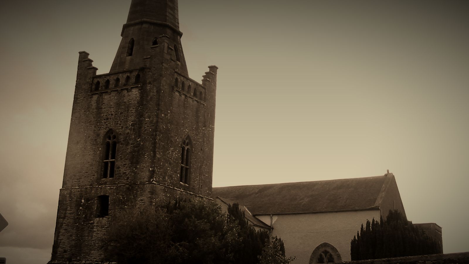 Stone tower and nave of St Columba's Church, Kells, on the site of the monastery where the Book of Kells was kept; sepia tones